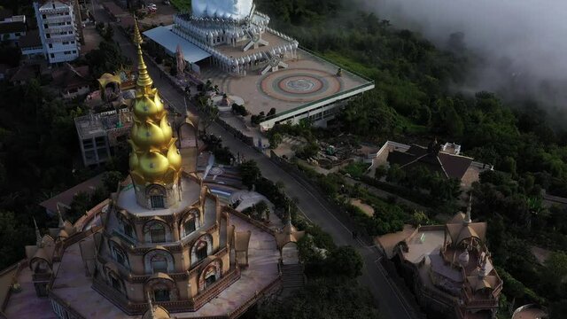 Aerial view of floating sea of clouds like cloud waves in mountains, Sea of fog, Sky above clouds, view on the mountain in the morning over amazing five buddha at Wat Pha Sorn Kaew in Thailand.
