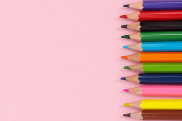 Multi-colored pencils on right side. Pink background. Banner on the site, copy space.