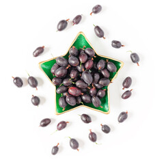 Berry composition. Ripe black gooseberries are in a star-shaped bowl. Creative berry concept. Flat lay. Top view.