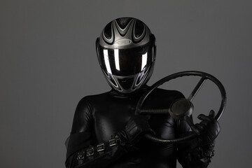studio portrait of a biker in a black helmet on a gray background