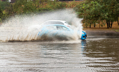Naklejka premium Driving cars on a flooded road during flooding caused by torrential rains. Cars float on water flooded streets. The disaster in Odessa