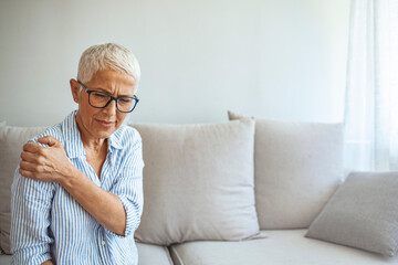 Senior woman with shoulder pain. Elderly woman is enduring awful ache. Neck and shoulder pain, old woman suffering from neck and shoulder injury, health problem concept