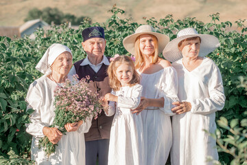 Portrait of a big happy family in a raspberry tree