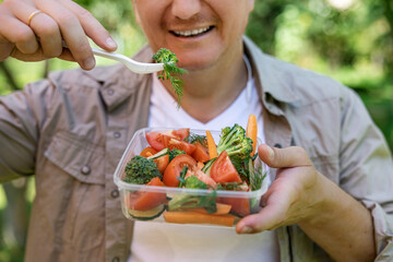 Close-up of a young man eating a fresh vegetable salad, shallow depth of field, selective focus....