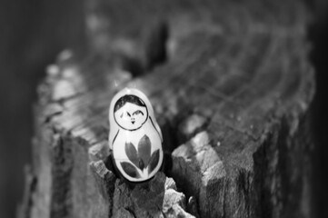 A small matryoshka doll on a wooden background.