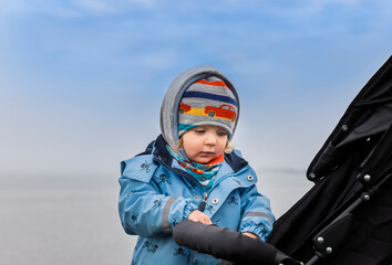 Fototapeta na wymiar Toddler girl examining safety belt and buckle of buggy