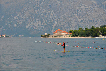 Kotor,Montenegro-08.01.2019 year. Close-up of a surfer with two ecotourists in the Bay of Kotor near the coast of the old city.