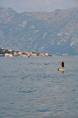 Kotor,Montenegro-08.01.2019 year. Close-up of a surfer with two ecotourists in the Bay of Kotor near the coast of the old city.