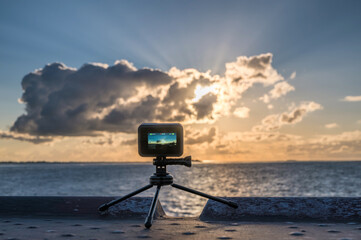 Kamera steht auf einem Stativ während eine Zeitrafferaufnahme des Sonnenunterganges gemacht wird