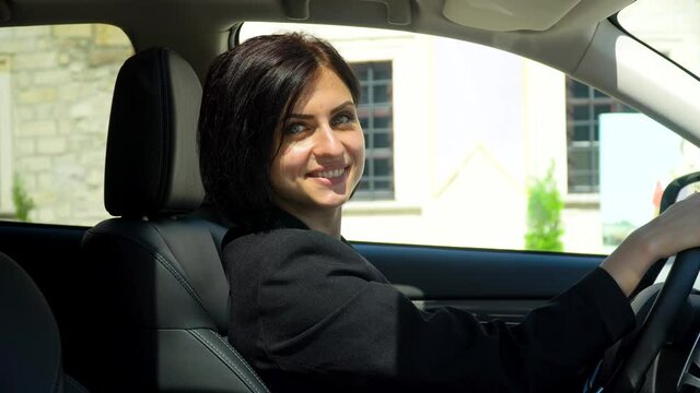 Stylish beautiful businesswoman sitting in car salon