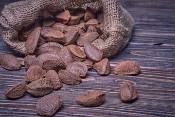 Paranuts in bag, vegetarian food in wooden bowls, on old wooden background