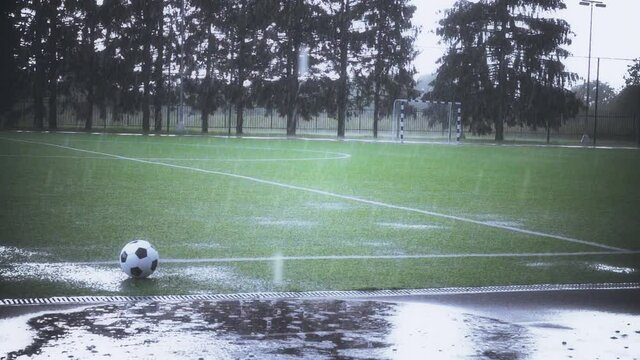 Slow motion shot of grass football field in heavy rain