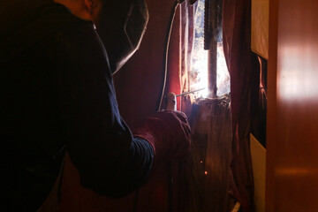 repairing of plumbing riser of heated towel rail at home - welder welds water pipe in wall by electric welding