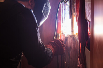 repairing of plumbing riser of heated towel rail at home - welder welds pipeline in wall by...