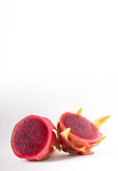 A pitaya or dragon fruit cut in half on a white background