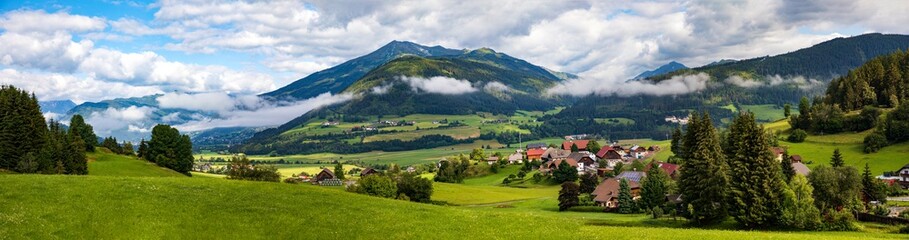 Fototapeta na wymiar Pichlern in Kärnten ein Panorama mit blauem Himmel und Wolken.