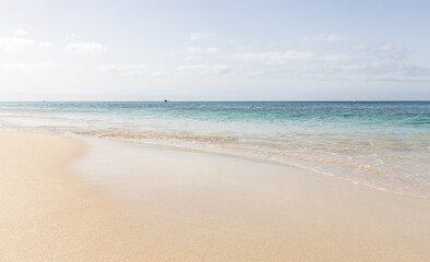 Fototapeta na wymiar PLaya de Morrojable en Fuerteventura en un dia soleado e con la agua azul turquesa