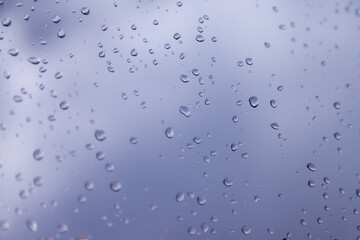 Background water drops. Raindrops on window panes. Natural pattern of rain drops. Abstract shot of raindrops on glass. Abstract falling rain drop of rain on glass. Place for an inscription or logo