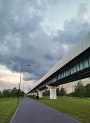 Fototapeta na wymiar Road in the Park. Clouds in the sky. Metro line.