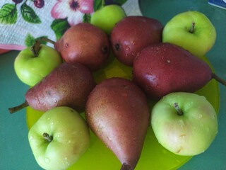 Food stilllife fruits apples pears on a yellow plate cookies and sweets on the kitchen table
