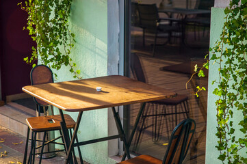 Summer terrace with modern metallic chairs and tables. Reastaurant tables waiting for customers on city street