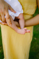 Mother holding her child wearing a yellow dress 