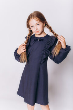 Back to school. Cute adorable caucasian blondie girl with glode in school uniform on white background
