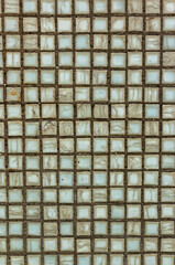 Old square background mosaic. Abstract pixels. Ceramic tiles. Texture for facing the walls of the house, bathroom, kitchen,tiled floor. Paint-stained gray mosaic tiles on the wall. Square mosaic tile