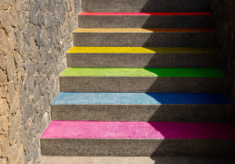 Gay pride flag represented on the steps of a staircase