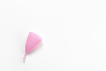 Pink menstrual cup on white background, copy space. Concept zero waste, savings, minimalism, these days. Feminine hygiene product, flat lay, top view. Horizontal