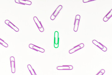 Business concept as a group of paperclip on white background with one individual in the center