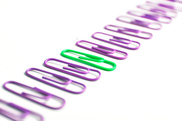 green paperclip along with many purple paperclips, unique iconcep