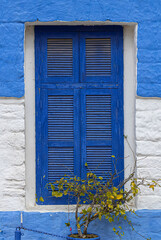 Blue and white window of a historic house in the medina of the historic center of Asilah in Morocco