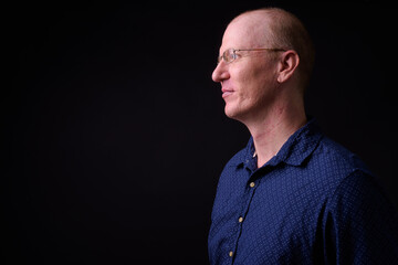 Profile view of bald businessman with eyeglasses
