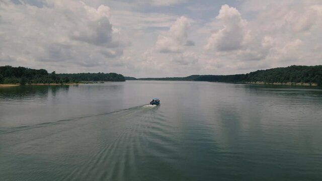 Circling around a speeding boat over Barren River Lake in Western Kentucky. Puffy clouds are reflecting on the water surface and make waves look pretty.