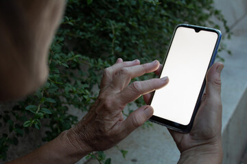 An elder person working on her phone