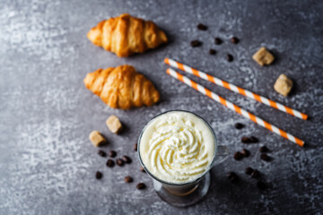 Coffee with whipped cream in a glass with coffee beans