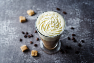 Coffee with whipped cream in a glass with coffee beans