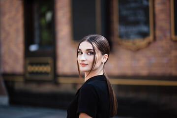 Portrait of a girl in the city. Girl in a black dress. Young beautiful woman. Makeup. Pretty Girl.