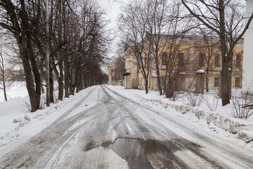 Snowy spring road in russian villiage