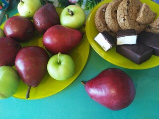 Fruits pears apples cookies on the yellow plate