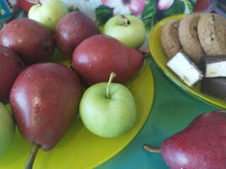 Fruits pears apples cookies on the yellow plate