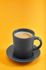 Cup of black coffee on a yellow background. Concept: Good morning, energy boost, motivation. Space for text