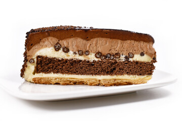 Slice of layered chocolate cream cake on plate isolated on white background