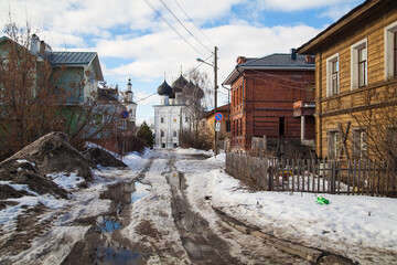 Fototapeta na wymiar Dirty spring road to church un small russian villiage