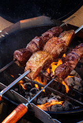 Barbecue dry aged wagyu picanha skewer preparing with salt on an open fire kettle grill  