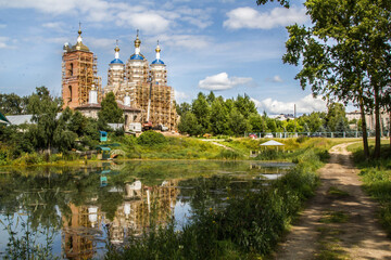 Obraz premium Restoration of old white orthodox church near dirty pond