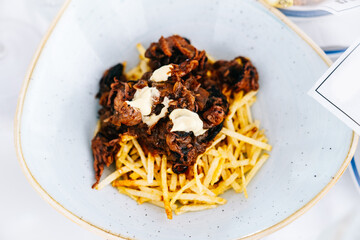 Dish with meat, mayonnaise and fried potatoes. Spanish tapas restaurant.