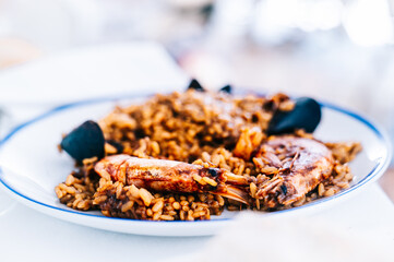 Spanish paella with shrimp and fish. Delicious rice dish in a restaurant. Typical food from Spain.