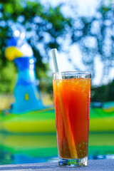 Homemade bubble tea in cocktail glass at pool with floats in background